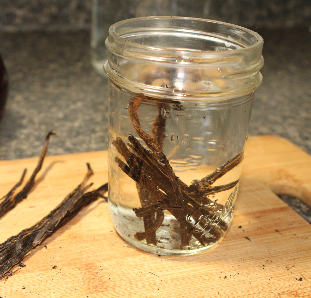 adding vodka to the jar of vanilla beans