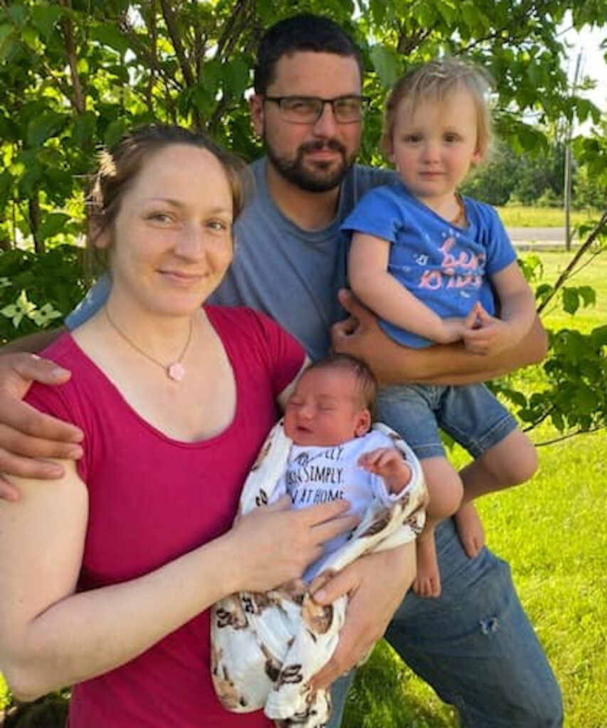family photo with mother and father and two children being held my them after a positive home birth