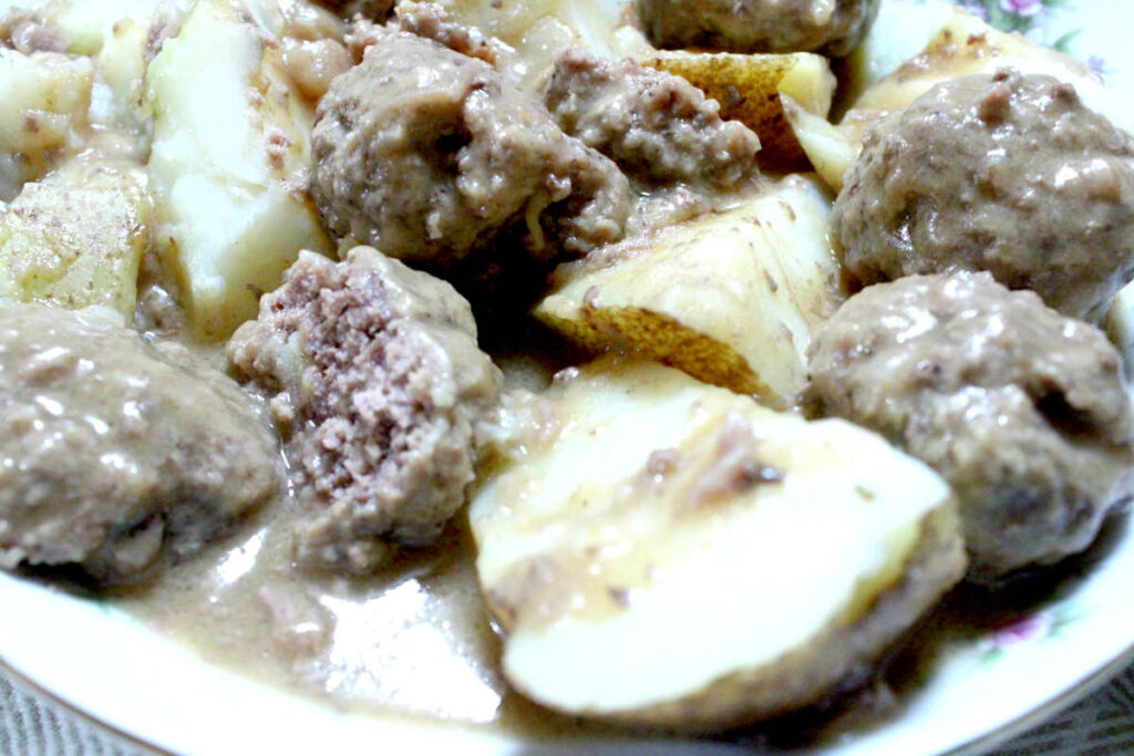boiled potatoes covered with meatballs and gravy