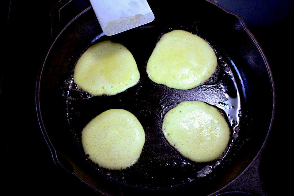 banana egg pancakes cooking on cast iron pan