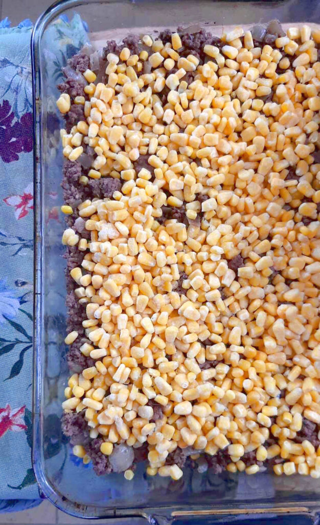 Chinese Pie whole corn spread on top of ground beef in casserole pan