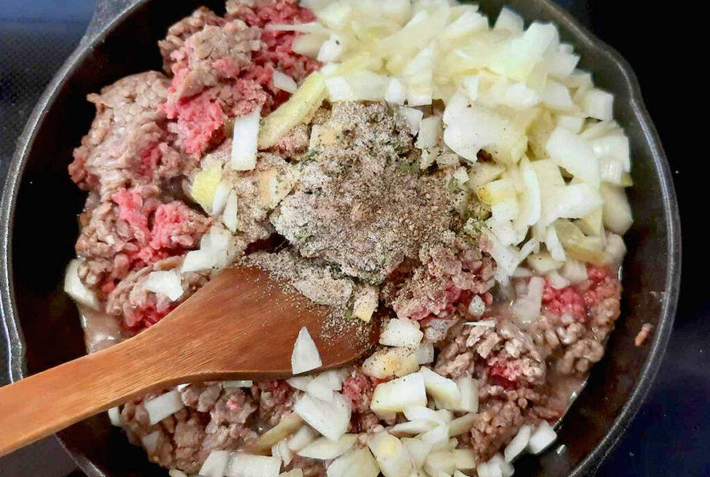 begin to cook onions ground beef and seasoning in skillet