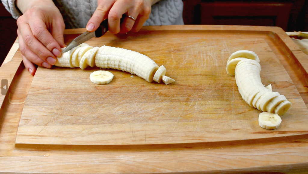 slicing bananas to 1/4 inch thickness on cutting board