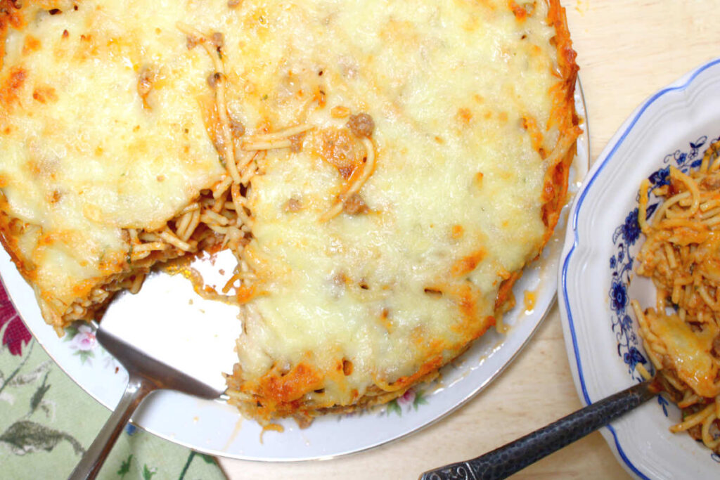 looking down on baked spaghetti pie with a triangular piece cut out