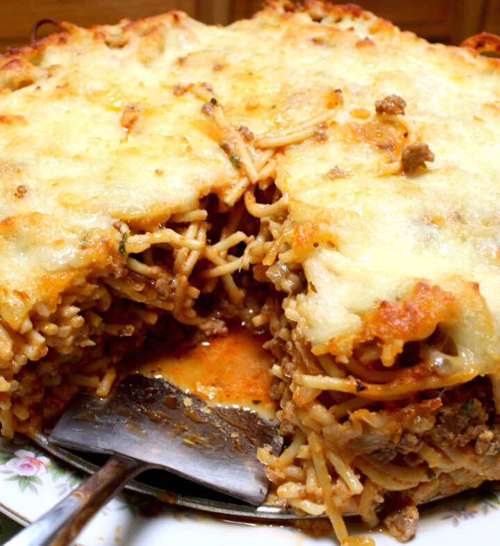 baked spaghetti pie on a plate with a piece cut out from it