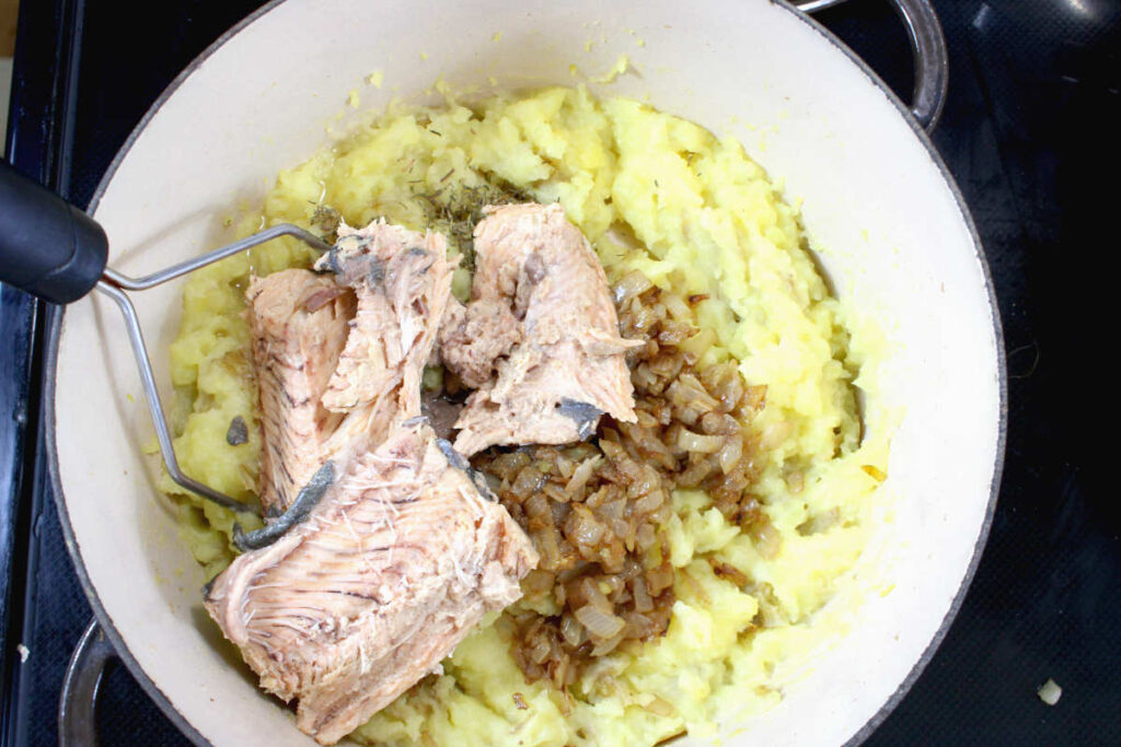 salmon pie, a pan with mashed potatoes, salmon and cooked onion mixture