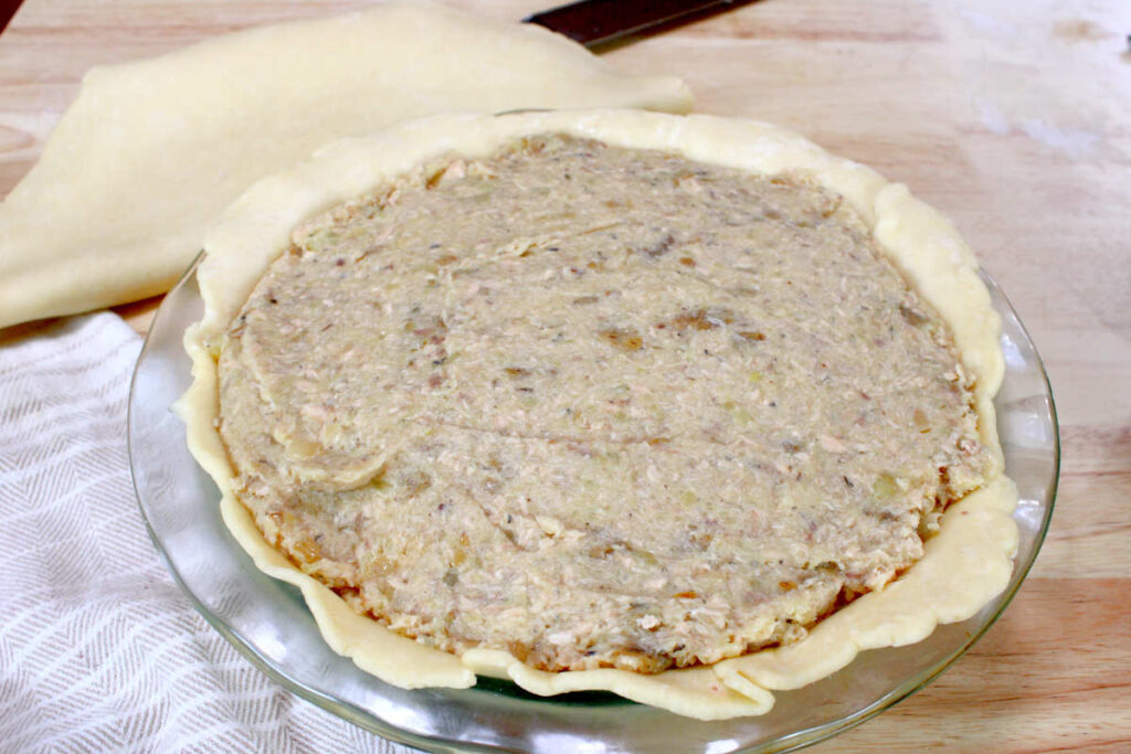 pie filled with salmon pie mixture ready for the top crust