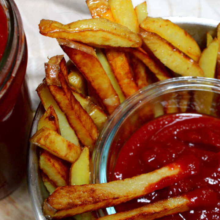 a bowl of ketchup with fries and a jar of homemade ketchup